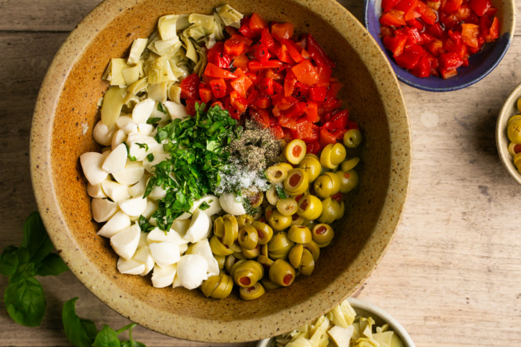 bowl with olives, artichokes, cheese, herbs, roasted red peppers