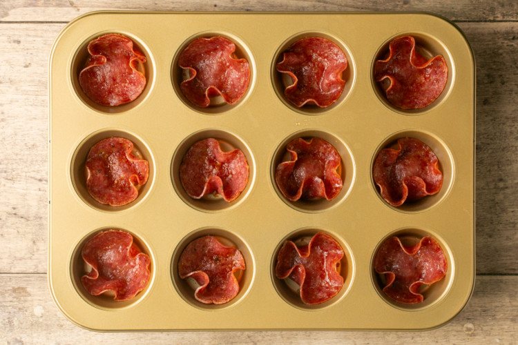 muffin tin with salami in each