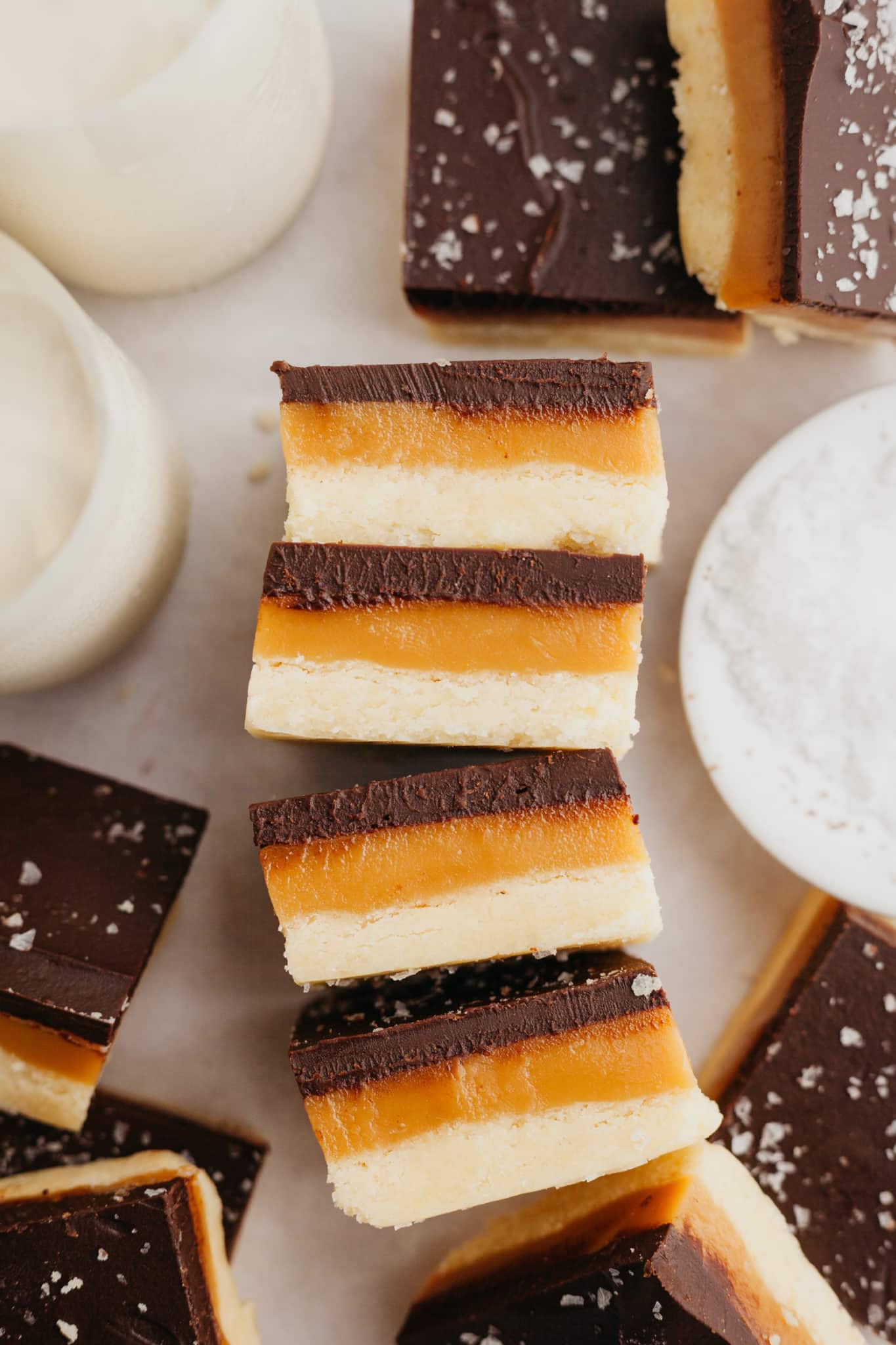 shortbread bars with caramel and chocolate stacked on top of each other. 