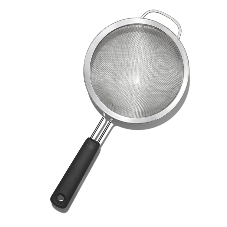 small gray sifter with a black handle