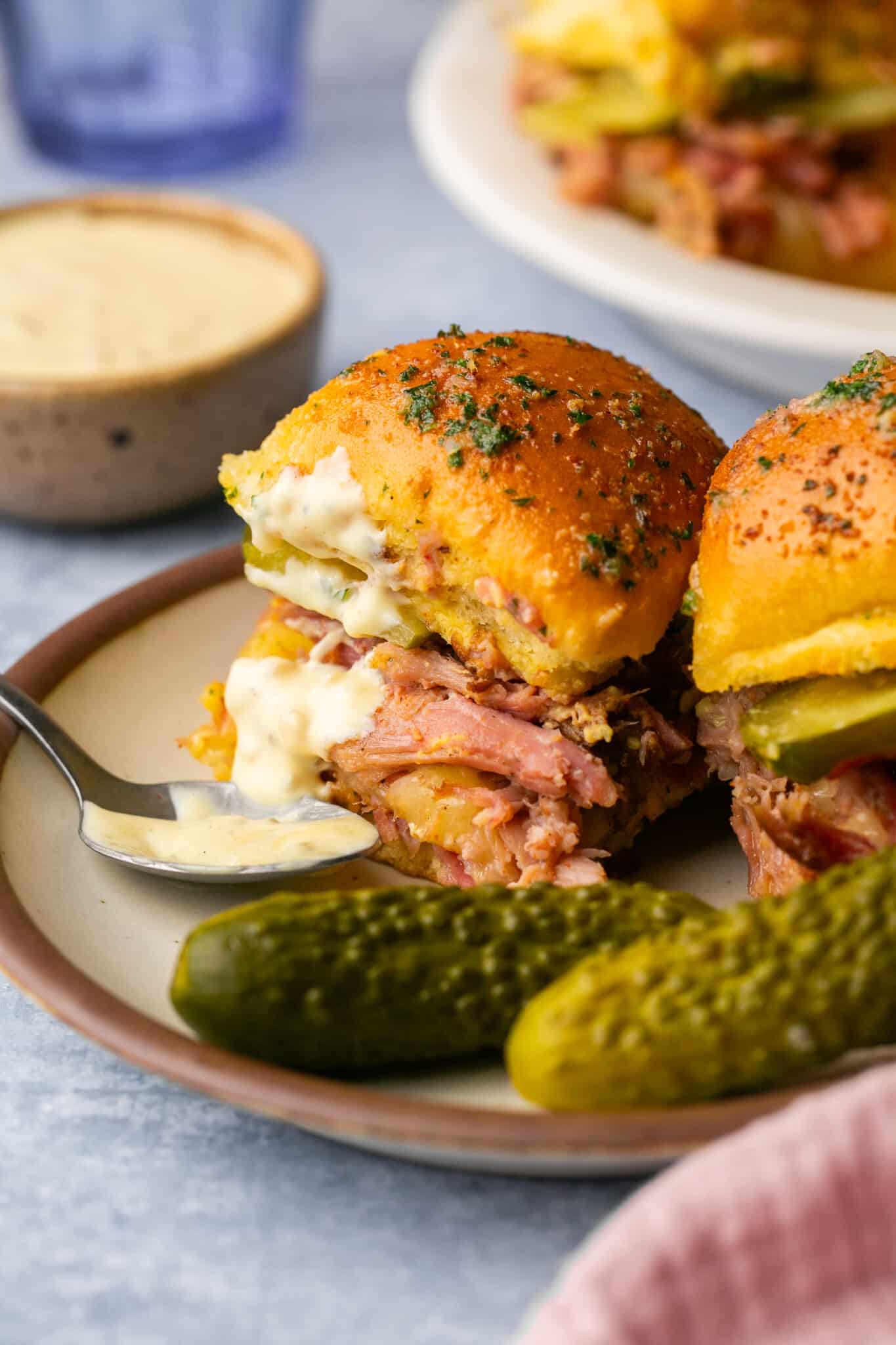 cuban sliders on a plate with aioli sauce on it.