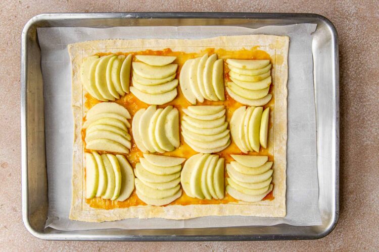 an apple tart on a baking sheet lined with parchment paper.