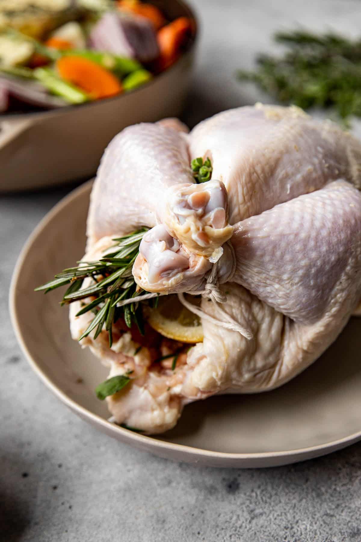 a roast chicken trussed and stuffed with herbs and lemon. 