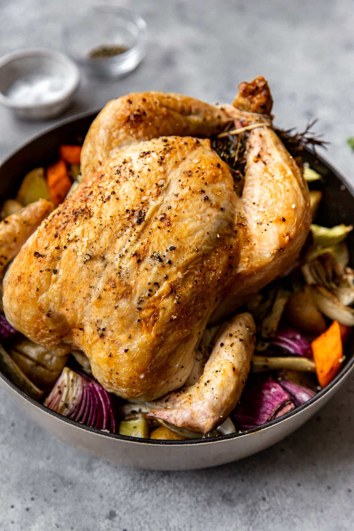 a roast chicken with vegetables in a pan. 