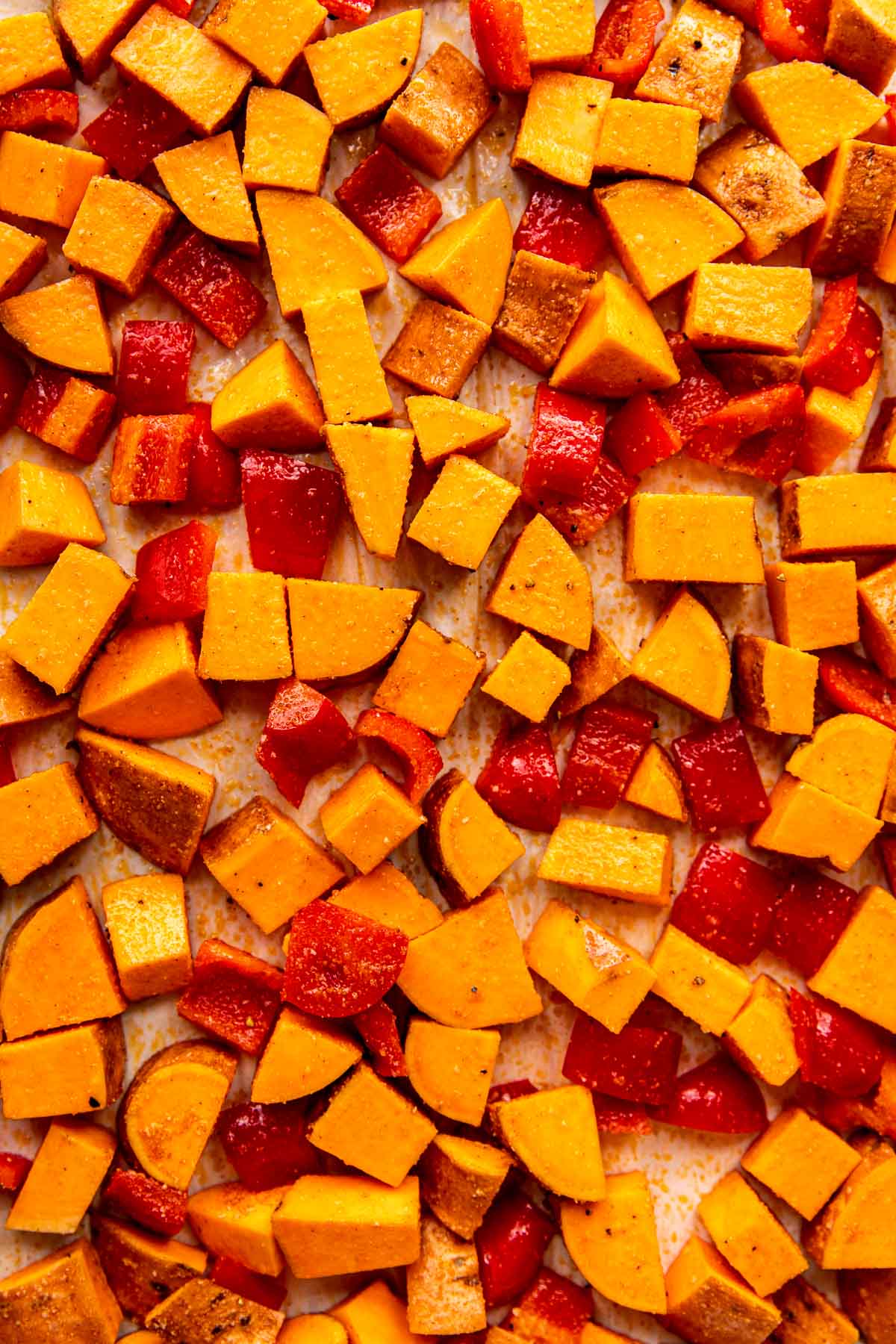 sweet potatoes and bell peppers on a sheet pan.