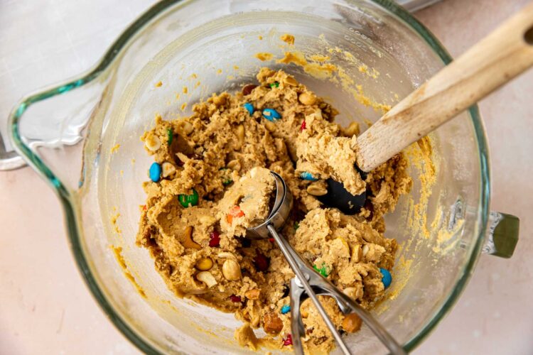 a cookie scoop scooping out some trail mix cookie dough.