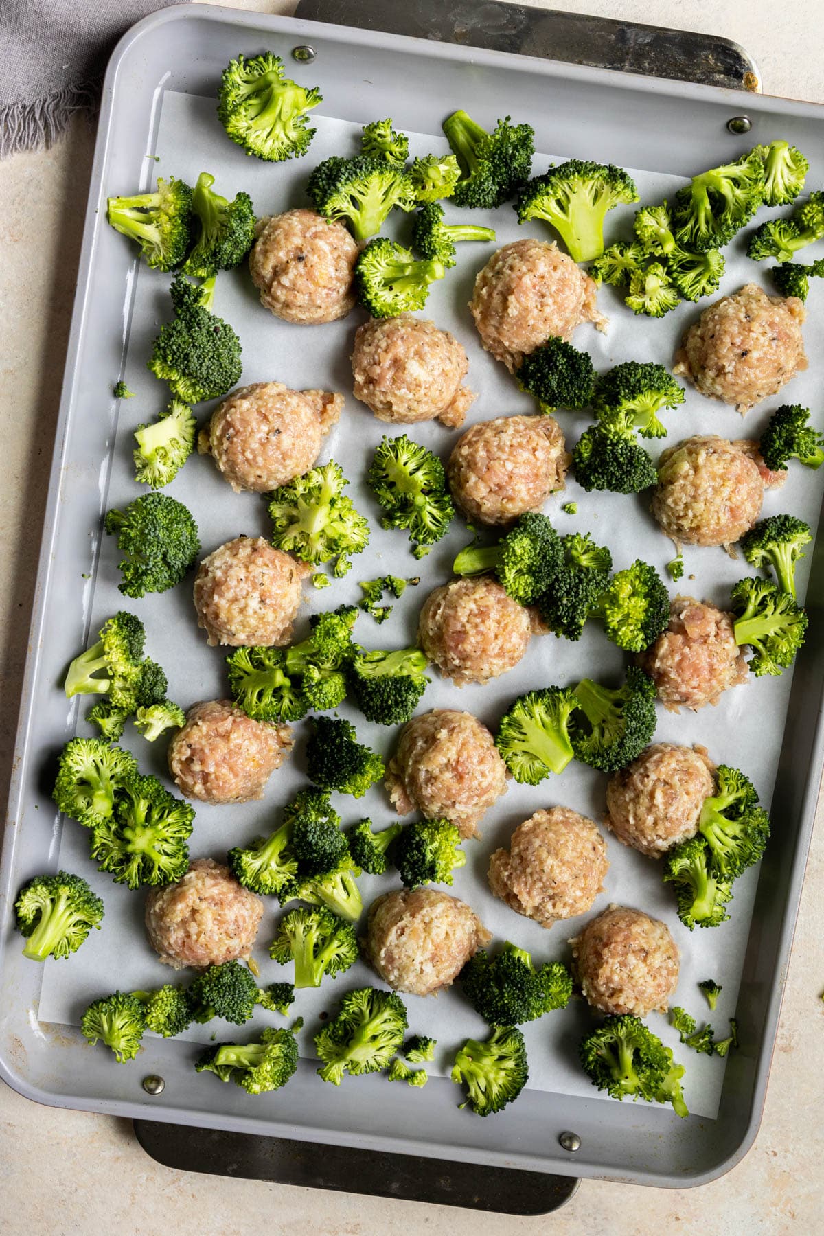 chicken meatballs and broccoli on a sheet pan. 