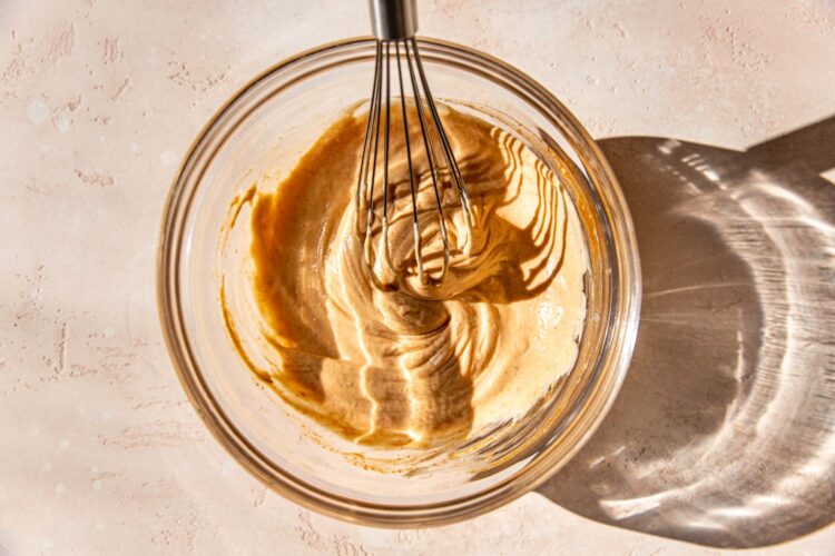 sriracha mayo in a glass bowl with a whisk.