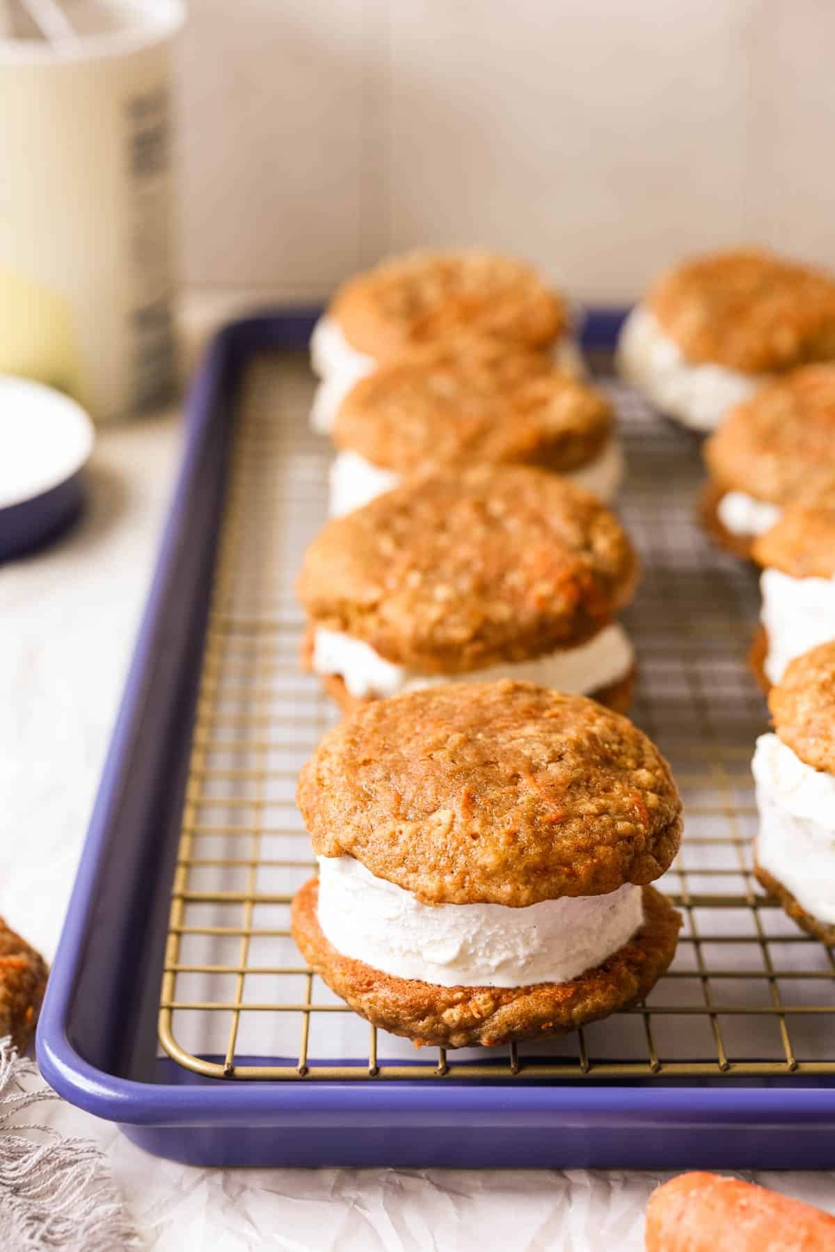 carrot cake cookie ice cream sandwiches on a gold wire rack. 