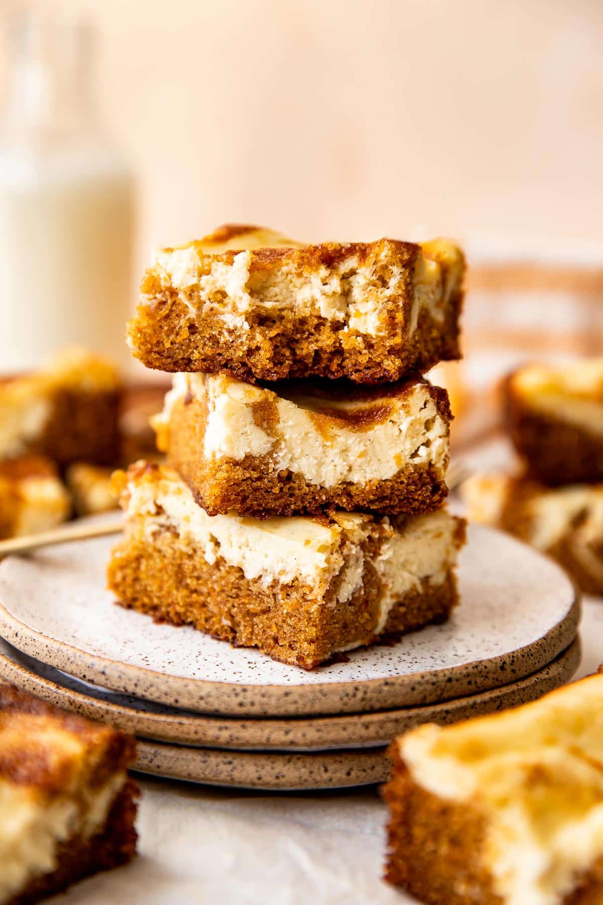 stacked carrot cake cheesecake bars on a plate. 