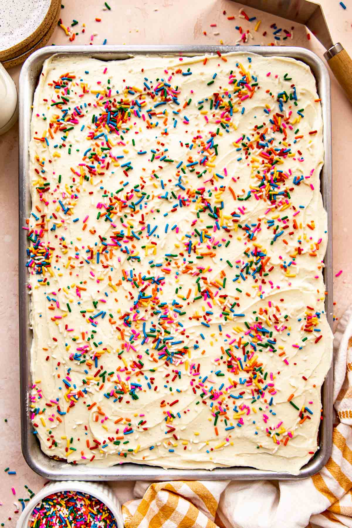 sheet pan funfetti cake with rainbow sprinkles on top.