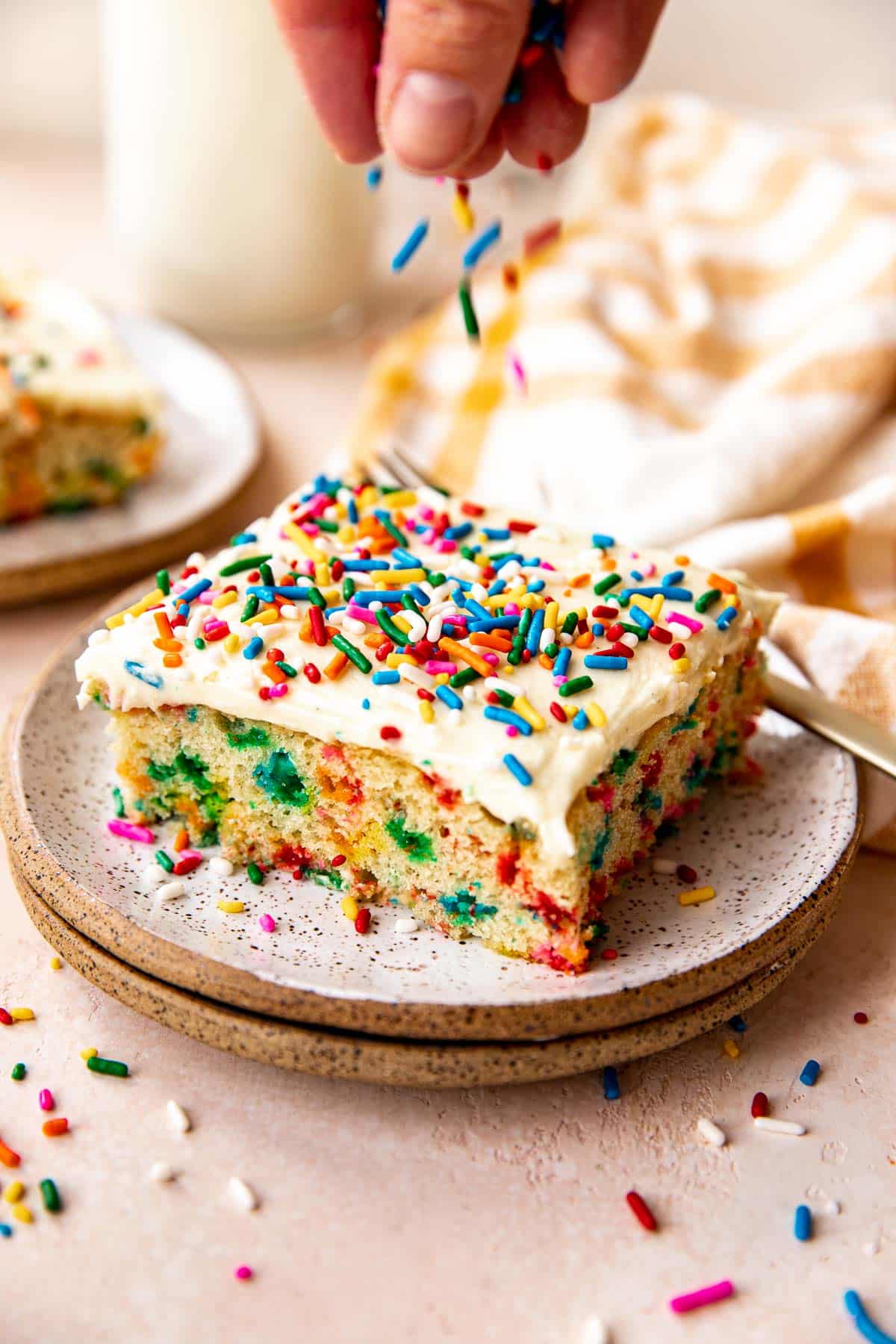 funfetti cake on a plate with sprinkles on top. 