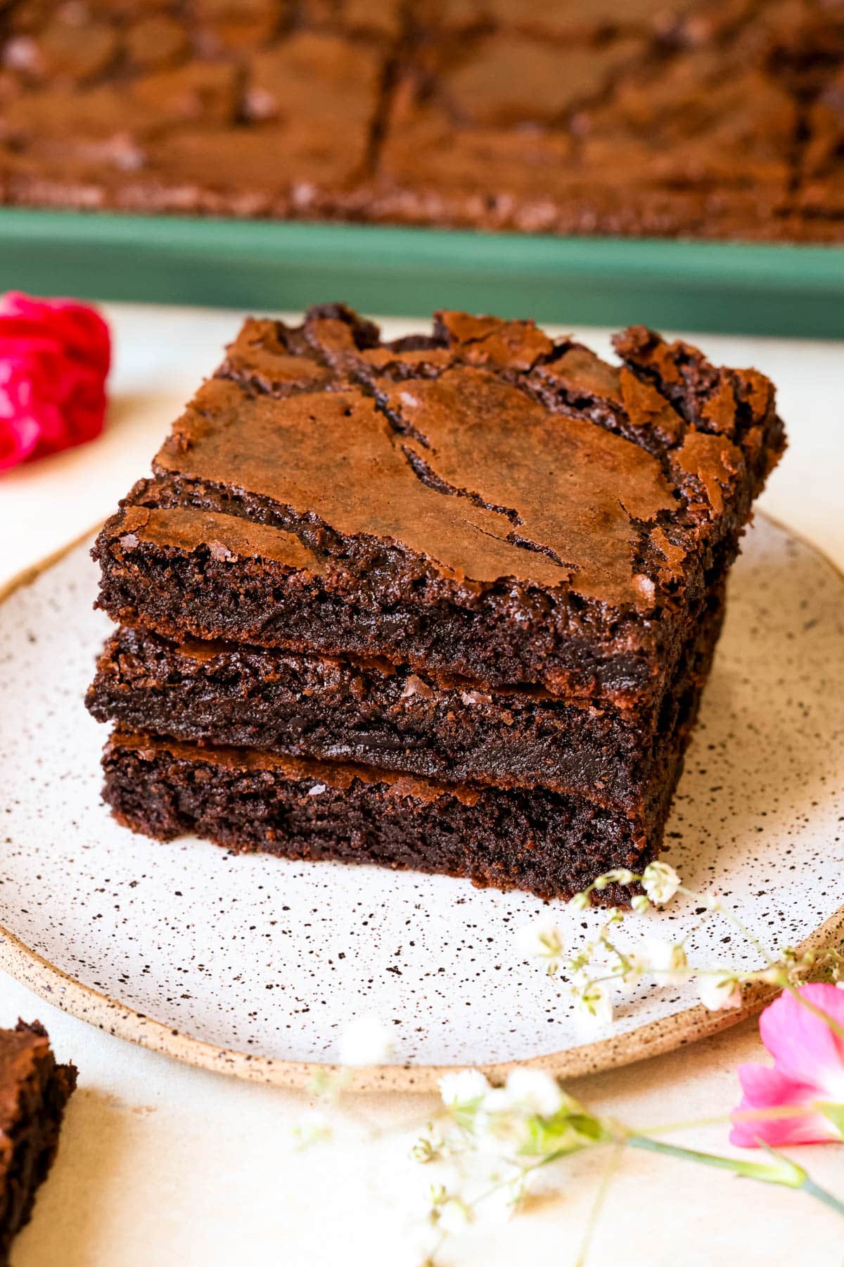 three brownies stacked together on a plate. 