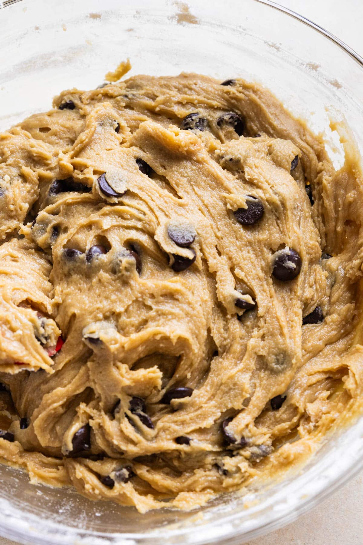 a glass bowl with cookie dough in it. 