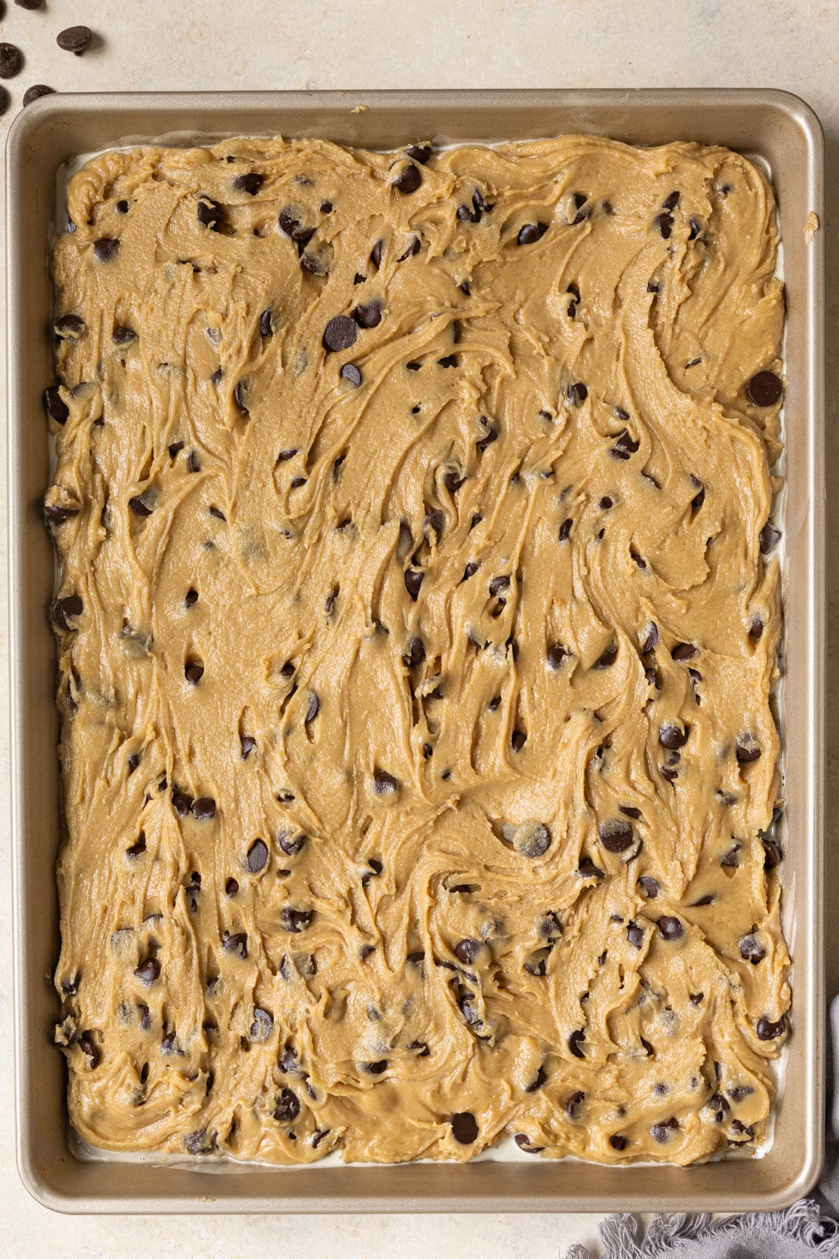 cookie dough spread out on a sheet pan. 