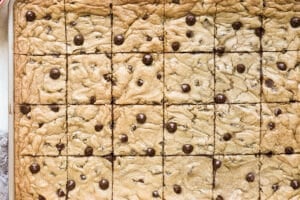 an up close image of chocolate chip cookies cut into squares on a sheet pan.