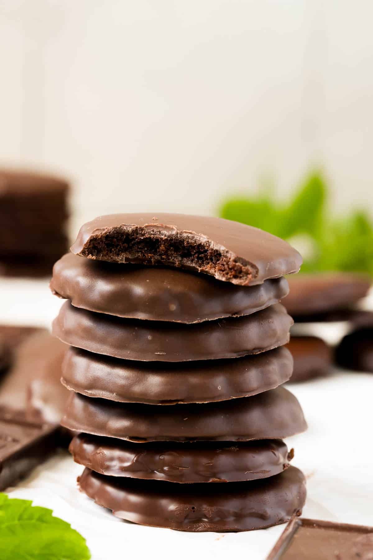 a stack of thin mint cookies with a bite taken out of the top cookie. 