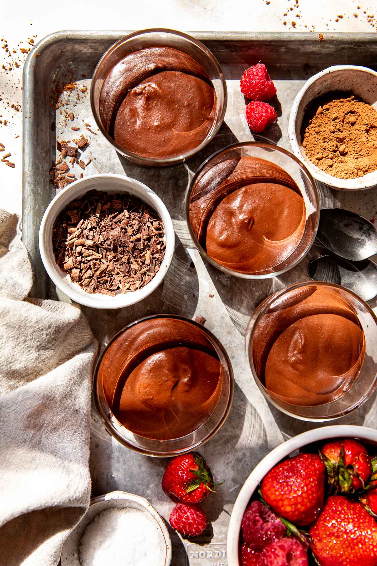 chocolate mousse in glass jars on a sheet pan. 