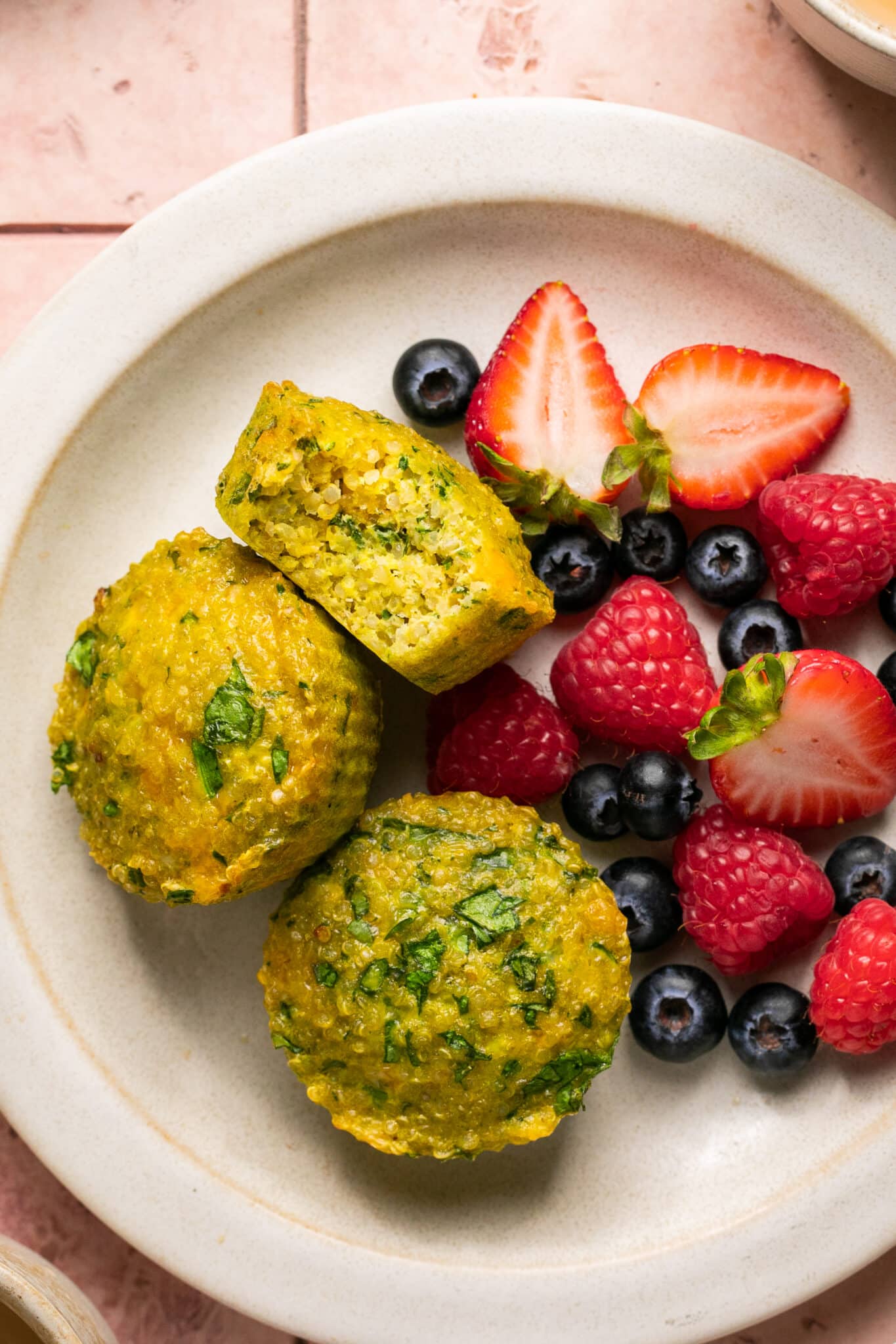 quinoa egg muffins on a plate with fresh berries. 