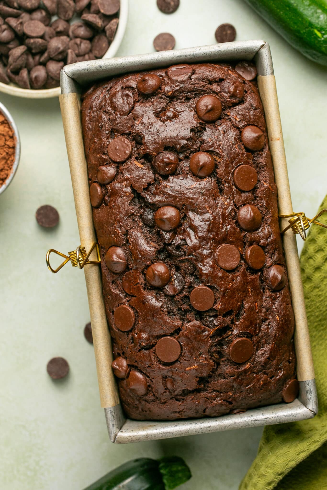 double chocolate zucchini bread loaf in a loaf pan lined with parchment paper. 