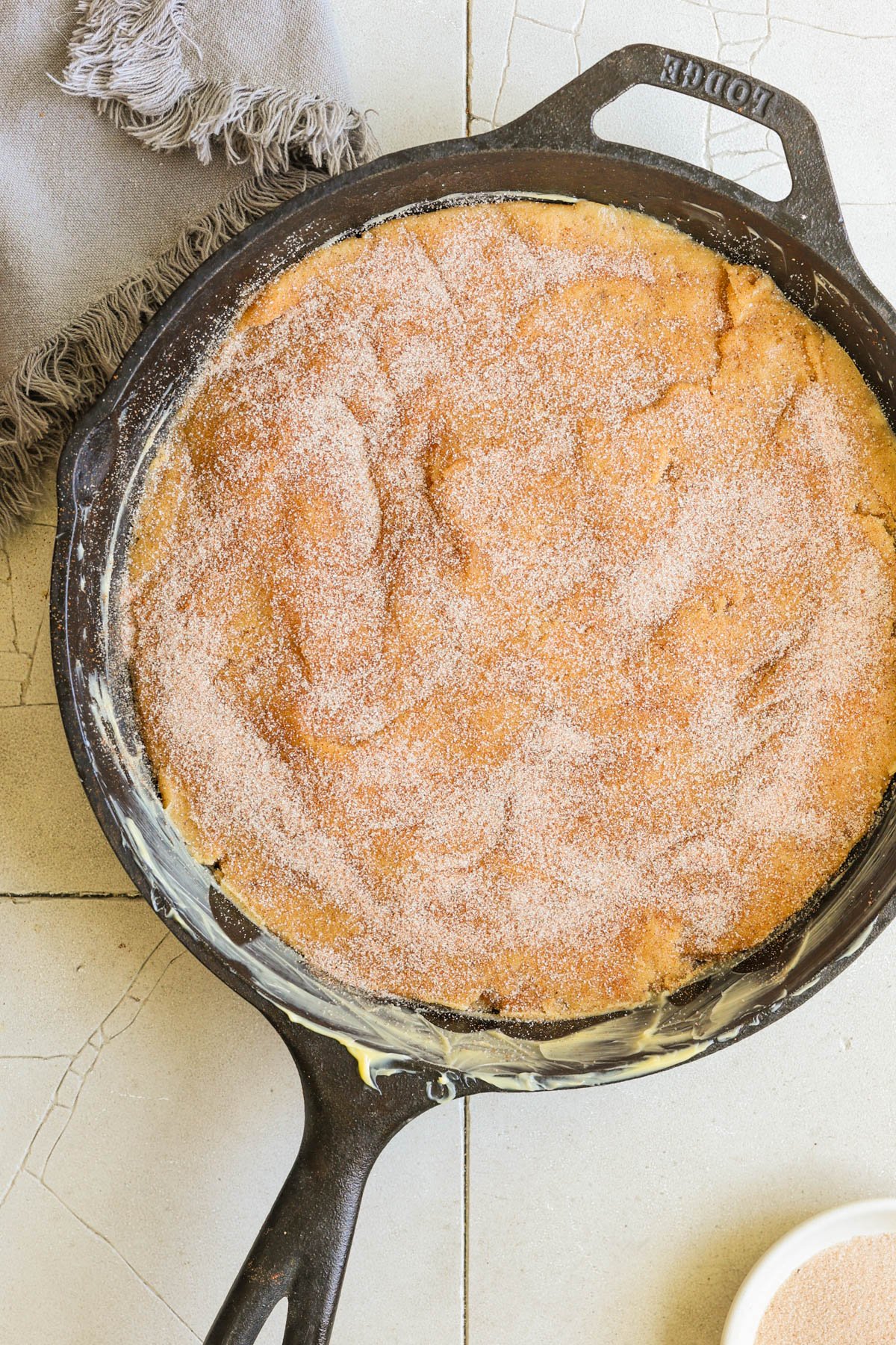 snickerdoodle cookie dough in a black cast iron skillet. 