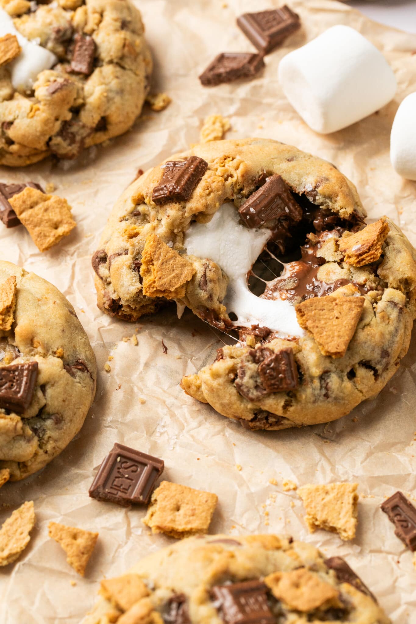 smores cookies on parchment paper decorated with hersheys chocolate and graham crackers. 
