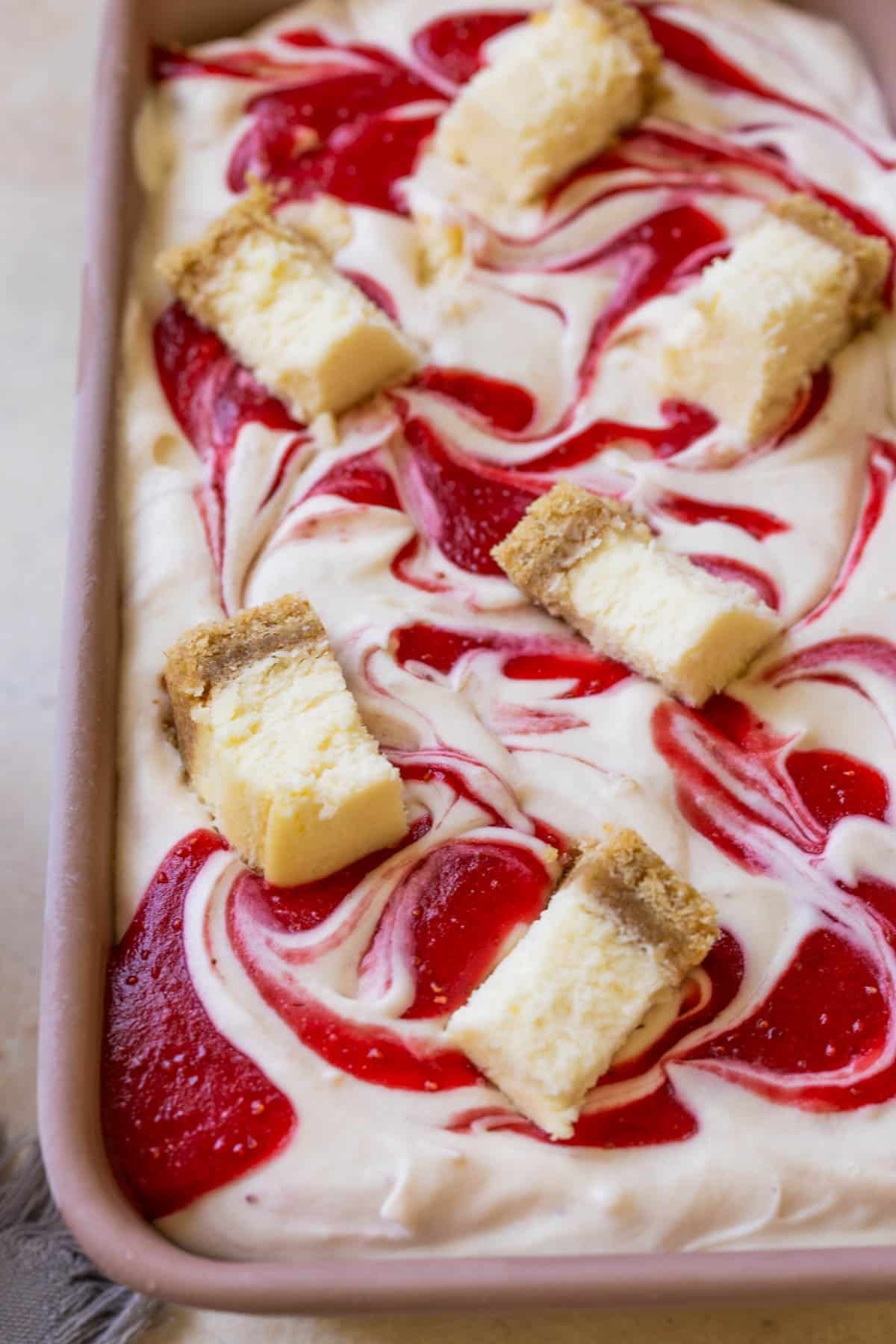 strawberry cheesecake ice cream topped with strawberry puree and cheesecake bites. 