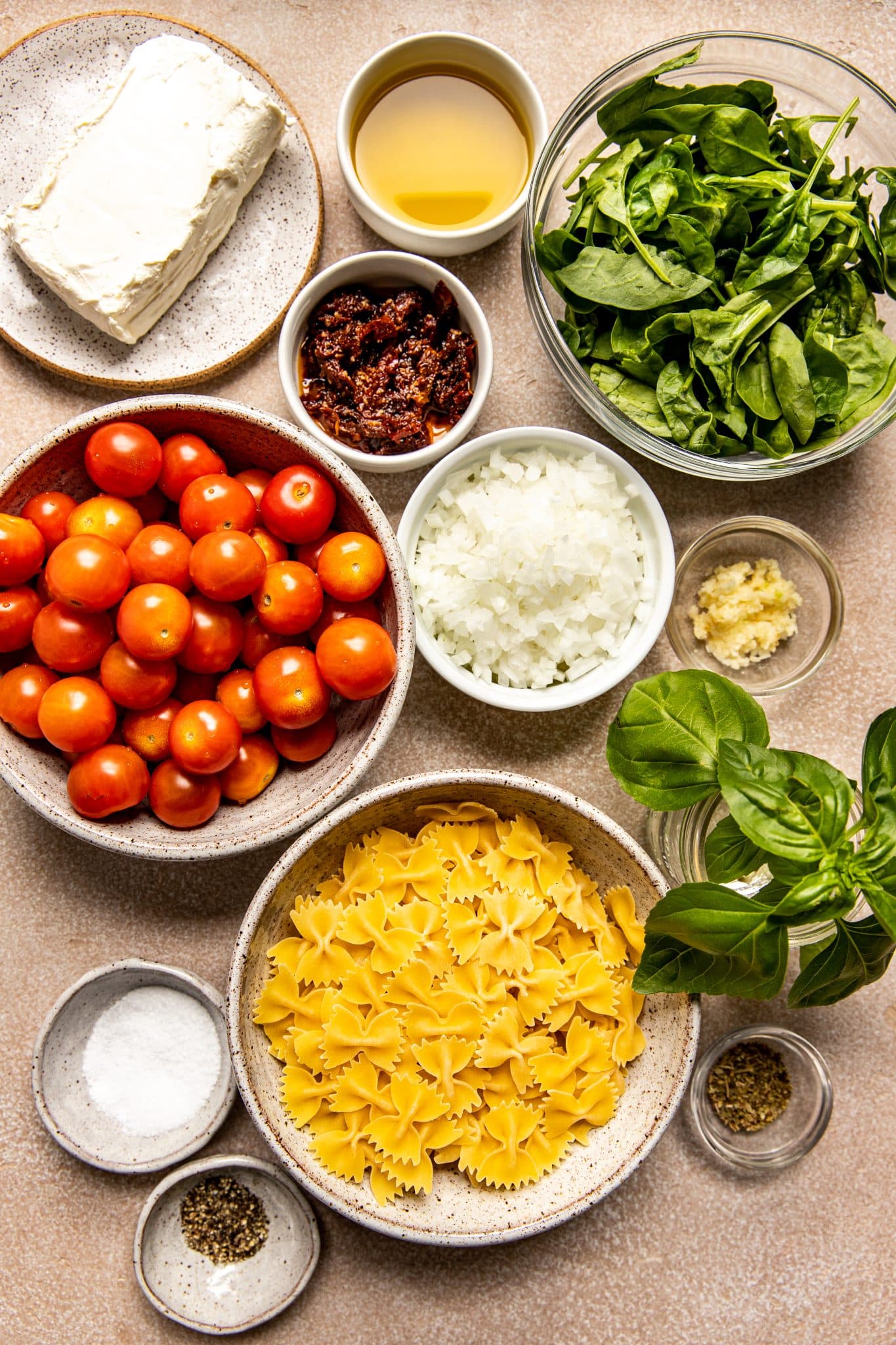 ingredients in small glass bowls needed to make a pasta. 