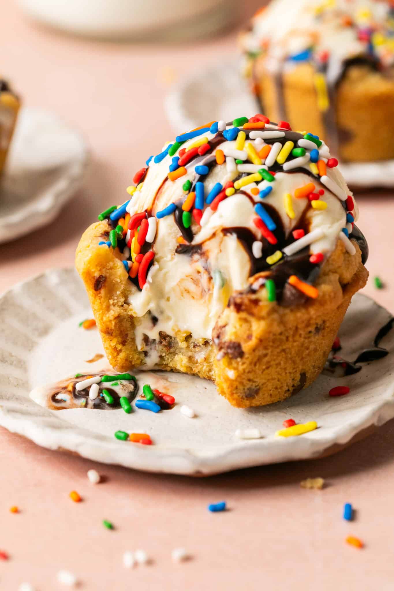 a cookie cup filled with a scoop of ice cream and decorated with sprinkles and chocolate sauce. 