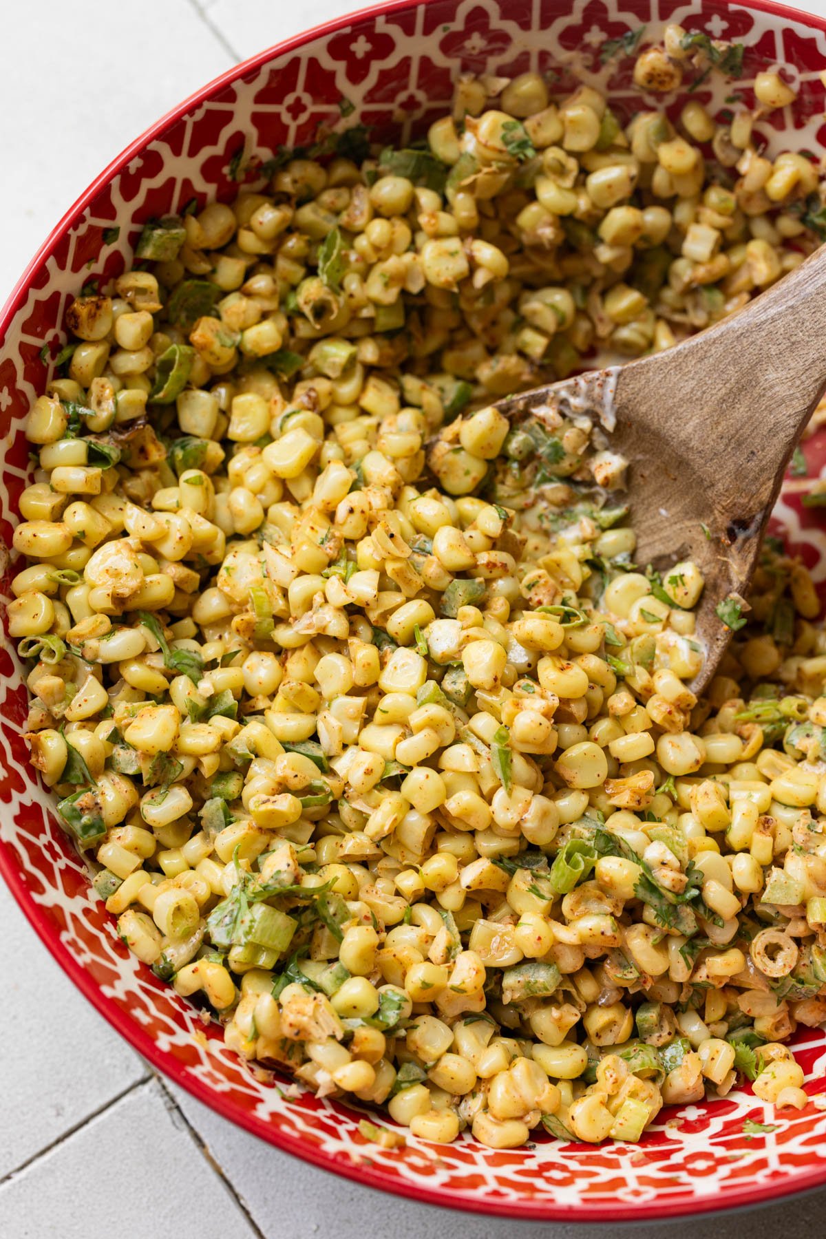 mexican street corn in a red and white bowl. 