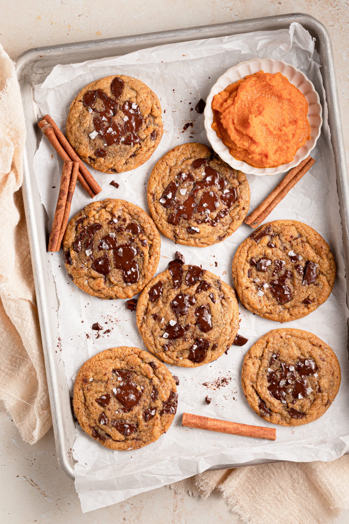 cookies on a baking sheet made with pumpkin and chocolate chunks. 