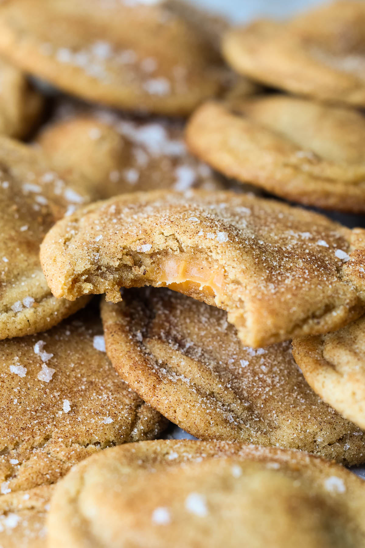 a bite taken out of a cookie stuffed with caramel in the center. 