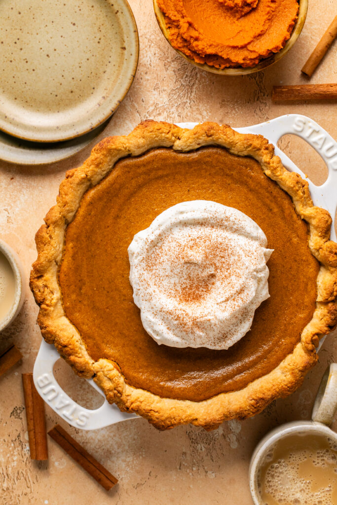 a pumpkin pie with homemade whipped cream on top. 