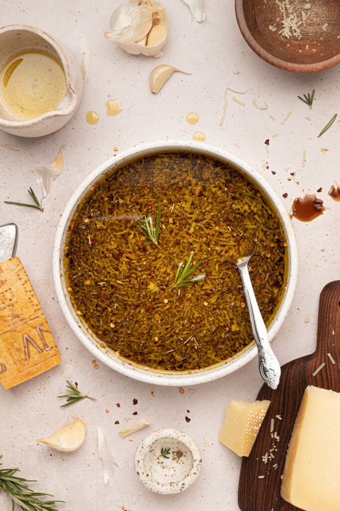 Bread dipping oil in bowl with serving spoon.