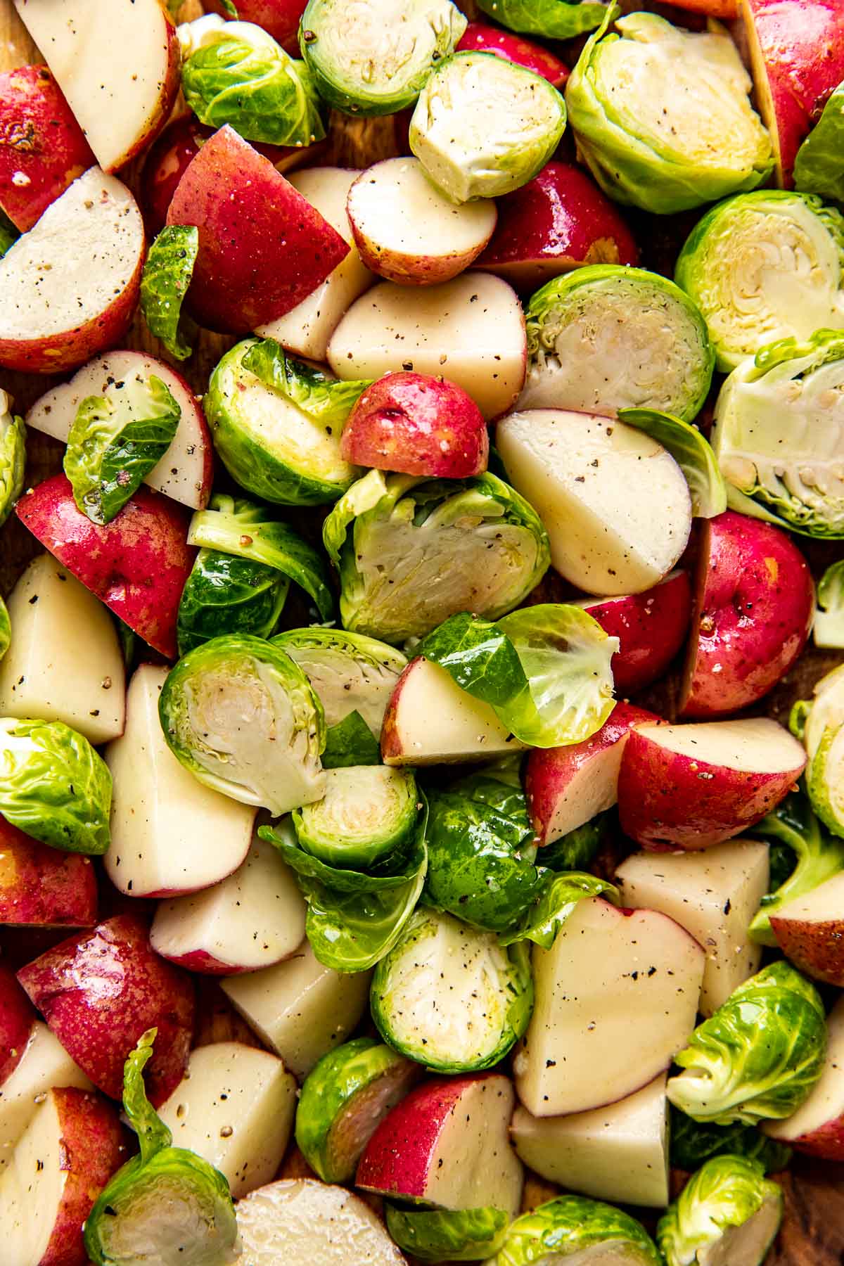 a close up image of potatoes and brussels sprouts. 