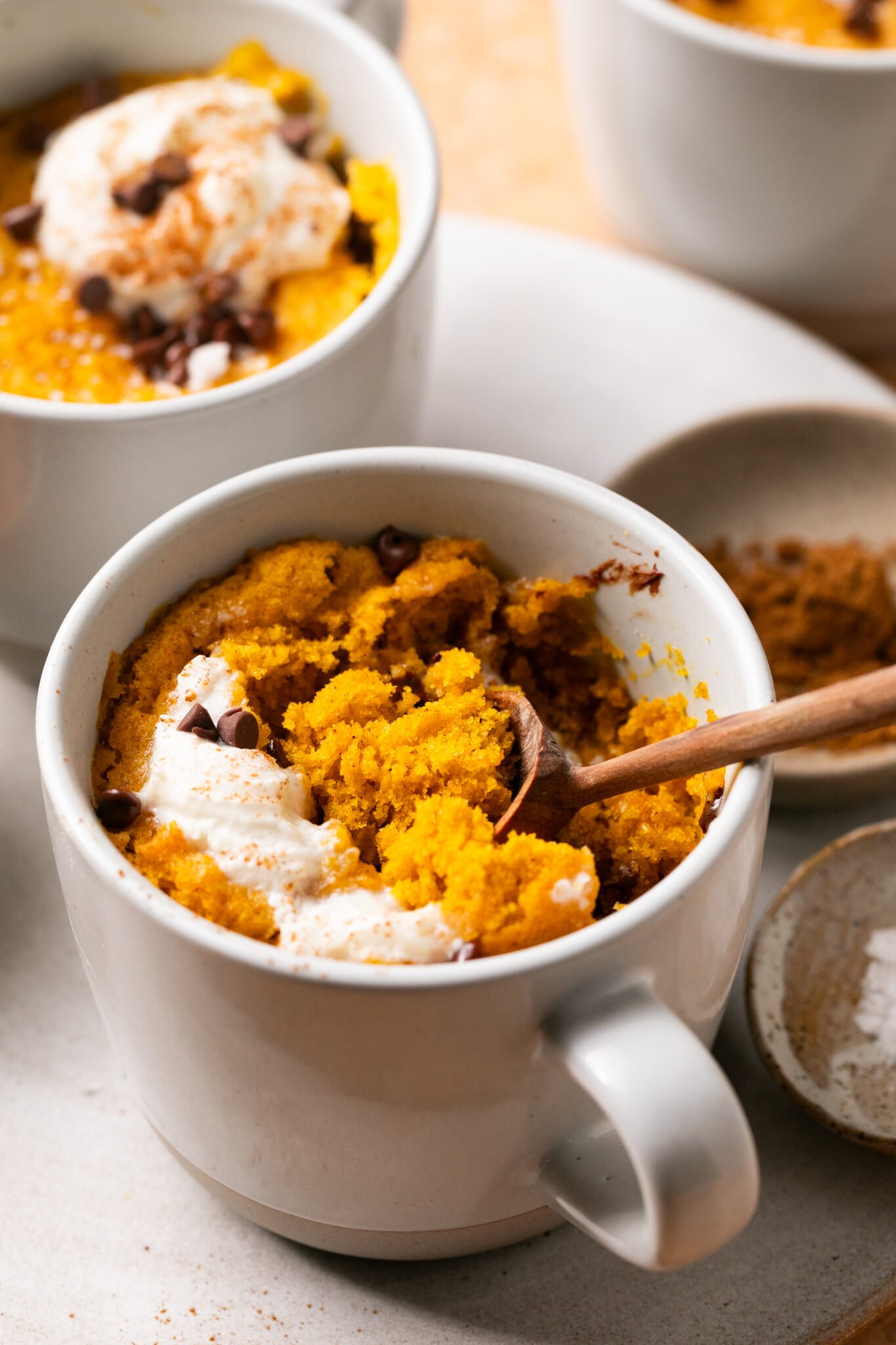 a spoon taking a bite out o a pumpkin mug cake.