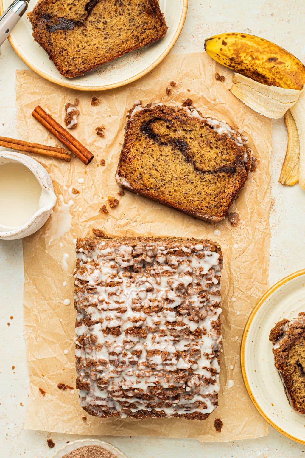 a slice cut off from a loaf of banana bread with icing drizzled on top.