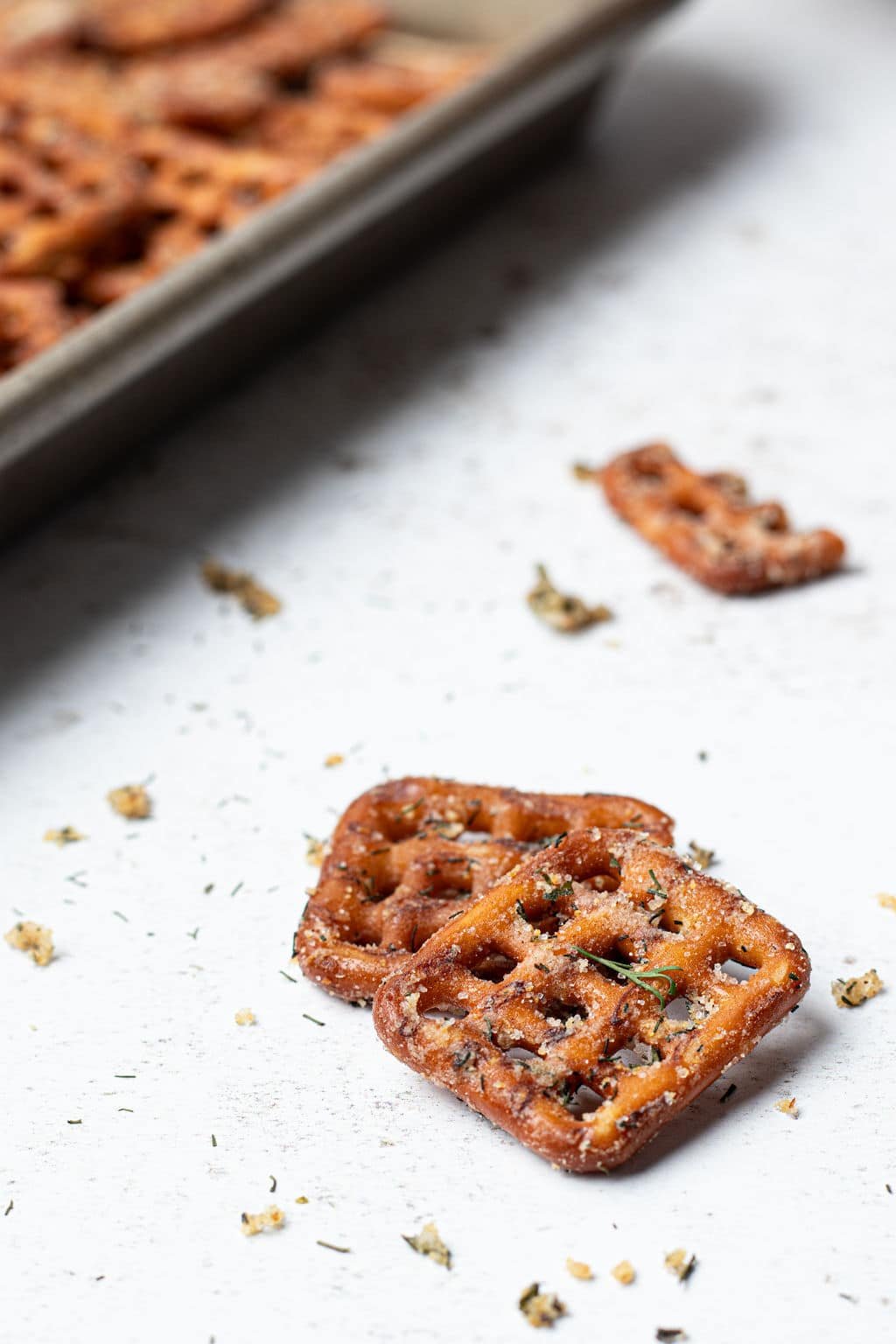 close up of 2 checkered square pretzels covered in spices