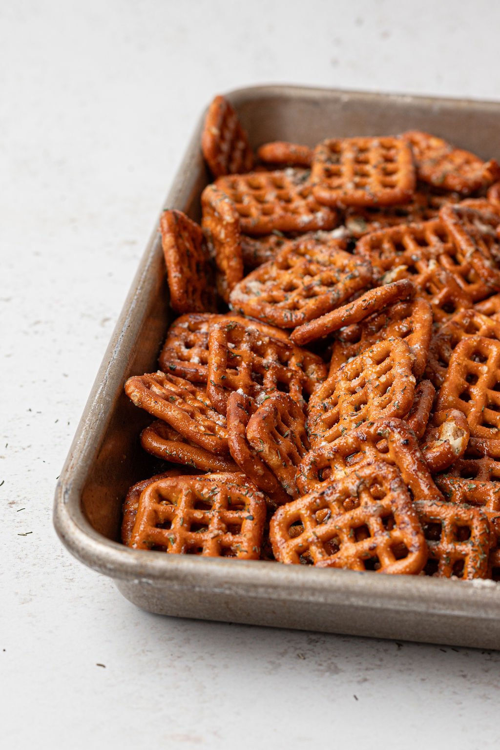 metal baking tray with square pretzels and seasonings