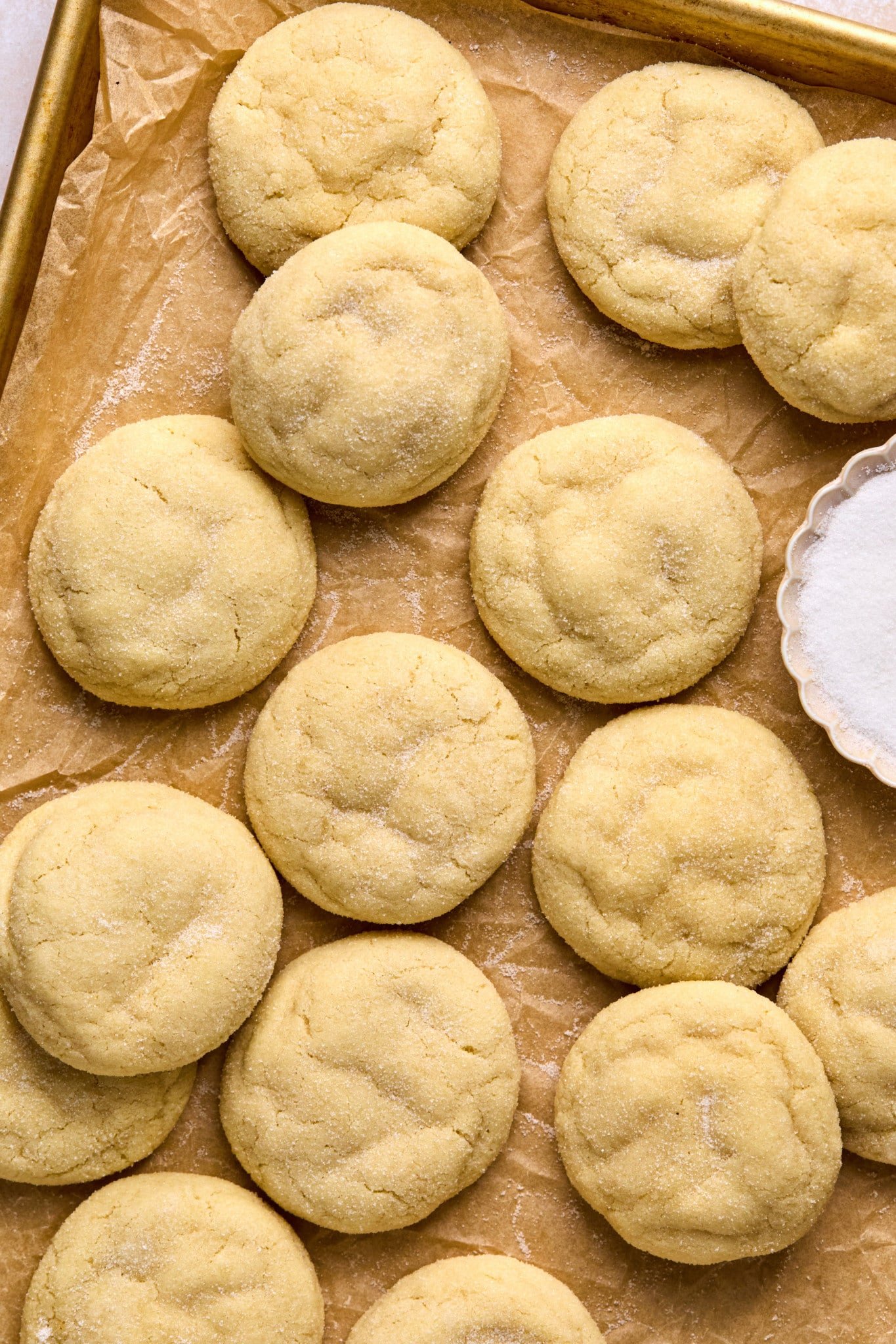 pile of baked sugar cookies on parchment paper