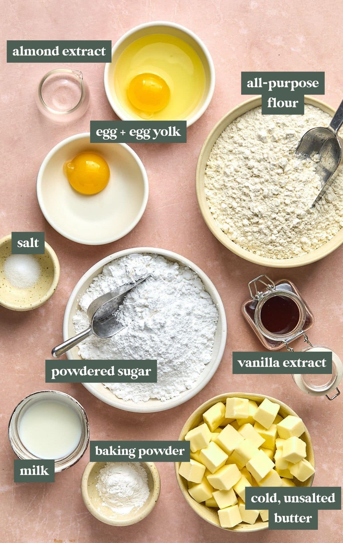 bowls with ingredients including flour, powdered sugar, vanilla extract, cold butter squares, salt, eggs, milk, and almond extract