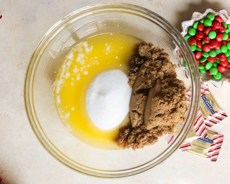 clear mixing bowl with melted butter, white sugar, and brown sugar