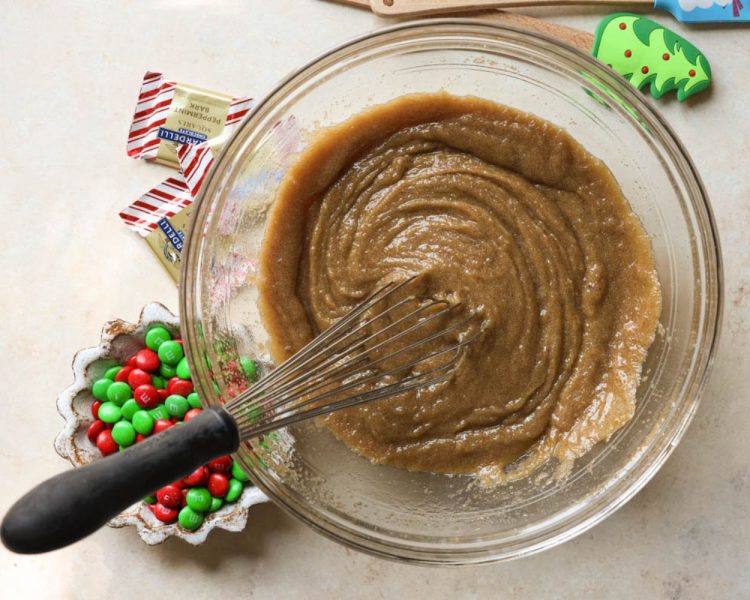 clear mixing bowl with melted butter, brown sugar and white sugar whisked together