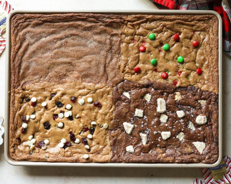 gold cookie sheet with four sections of cookies. top left is gingerbread, top right is m&ms, bottom left is white chocolate cranberry, bottom right is chocolate peppermint