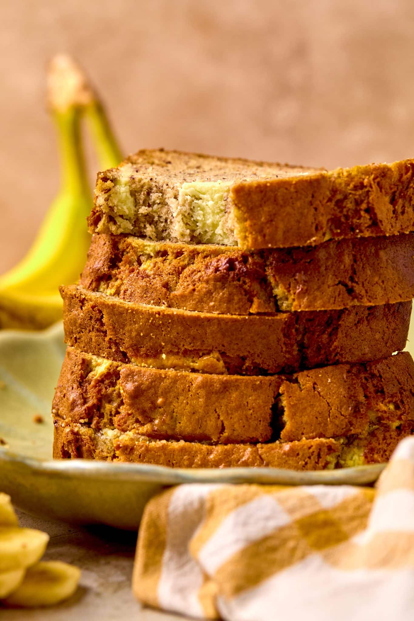 stacked banana bread with a bite taken out of the top slice. 