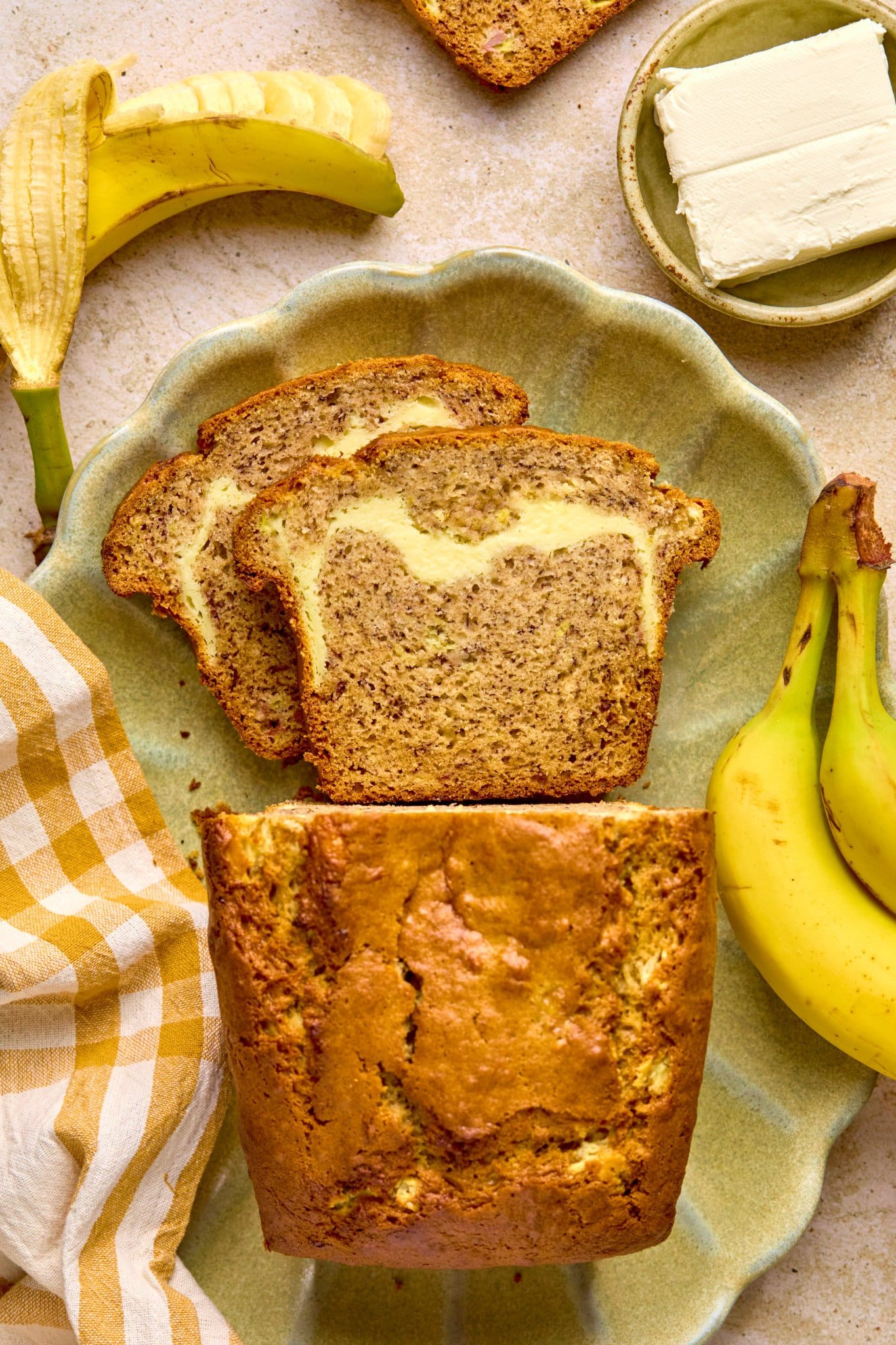 cheesecake banana bread on a light green serving platter. 