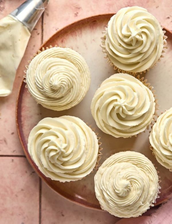 cupcakes topped with vanilla frosting on a plate