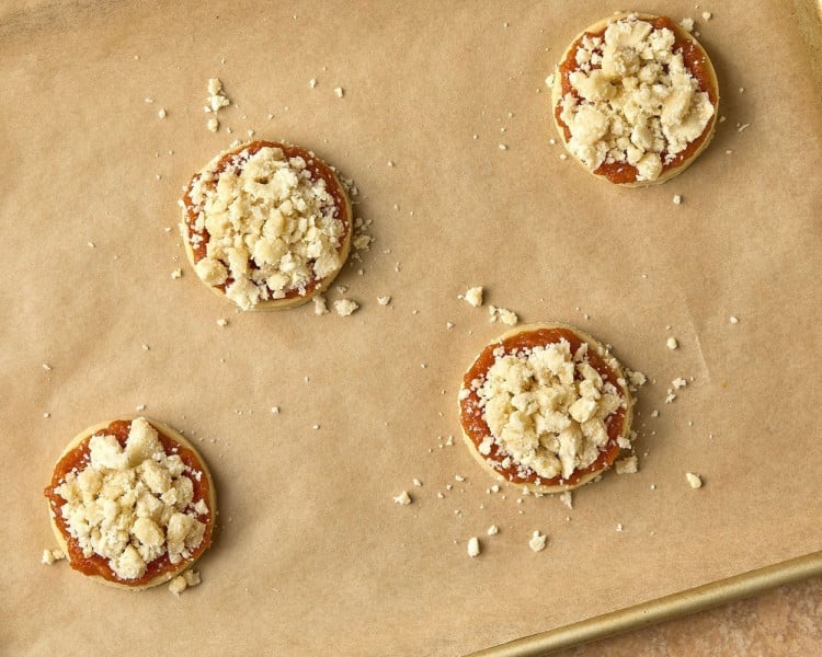 cookies with pumpkin spread and crumbles on top before baking