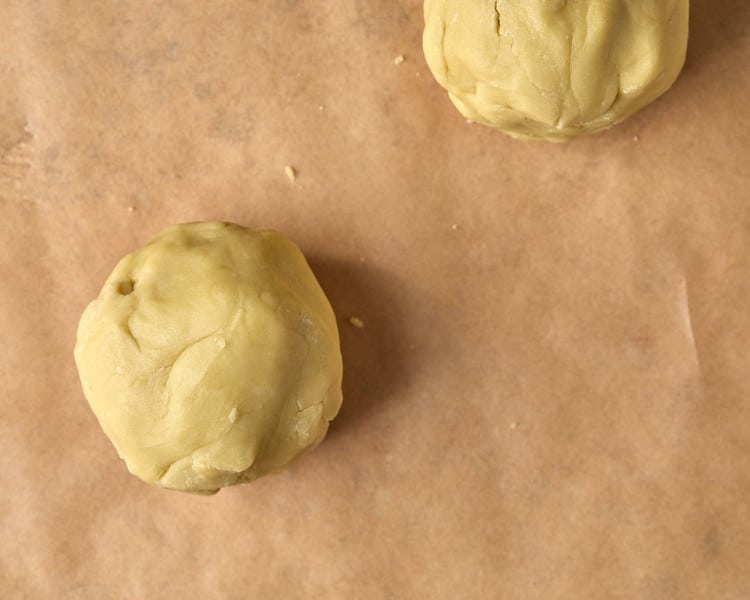 two balls of cookie dough on parchment paper