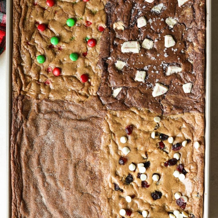 gold sheet pan with four types of cookies - m&m, chocolate peppermint, gingerbread, and cranberry white chocolate chip